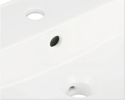 Detailansicht eines Waschbeckens mit Hahnloch und Überlauf