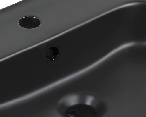 Detailansicht eines schwarzen Waschtisches mit Armaturloch und Überlauf