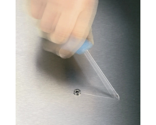 Une goutte de colle est appliquée sur une vis