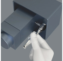 Eine Hand benutzt eine Knarre, um eine Schraube festzuziehen.