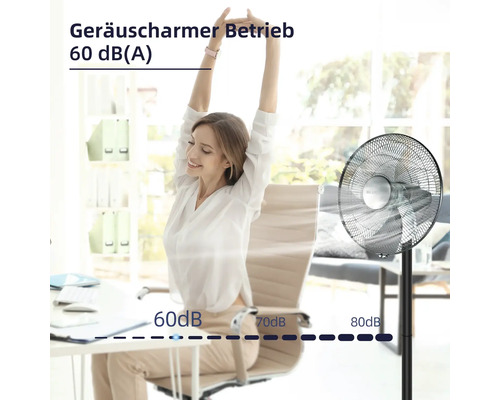 Szene mit einer Frau an einem Schreibtisch und einem Standventilator, der einen geräuscharmen Betrieb von 60 Dezibel bietet