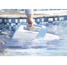 Une main tient un nettoyeur de piscine automatique dans l''eau