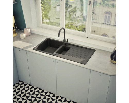 Küchenspüle mit Abtropffläche und Armatur unter einem Fenster