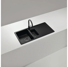 Schwarze Küchenspüle mit Abtropffläche und Wasserhahn auf einer Küchentheke