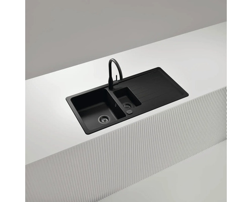 Schwarze Küchenspüle mit Abtropffläche und Wasserhahn auf einer Küchentheke