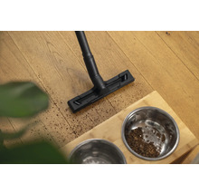Aspirateur nettoyant le sol près d''une gamelle pour animaux