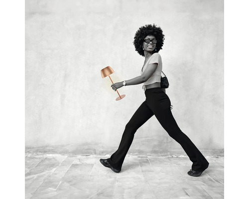 Femme marchant avec une lampe de table.