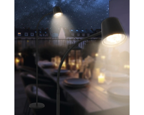 Deux lampadaires éclairent une table d''extérieur sous le ciel étoilé.
