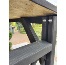 Detailansicht eines Gartentisches mit Holzplatte und dunklem Holzgestell