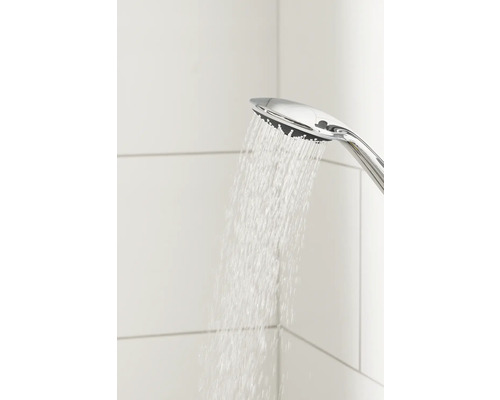 Douchette à main avec eau courante devant un mur carrelé blanc