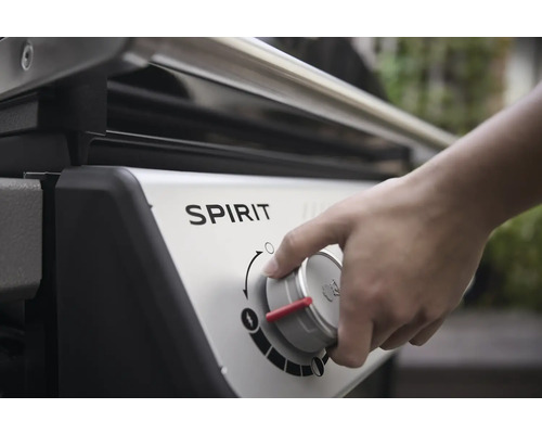 Nahaufnahme eines Spirit Gasgrills, bei dem eine Hand einen Regler bedient.
