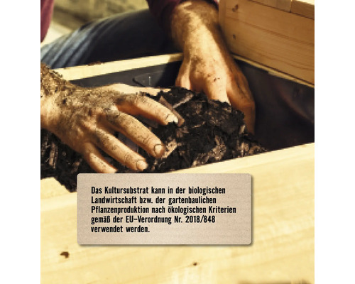 Person füllt Pflanzsubstrat in ein Hochbeet. Das Kultursubstrat kann in der biologischen Landwirtschaft verwendet werden.