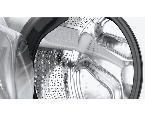 Gros plan du tambour en acier inoxydable d''un lave-linge avec trous et nervures d''entraînement