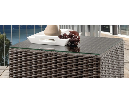 Table de jardin en rotin avec plateau en verre et décoration
