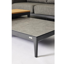 Gros plan d'une table de jardin avec un plateau gris et un cadre sombre.