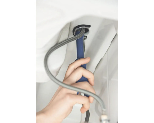 Une personne installe un lavabo avec une clé d''installation.