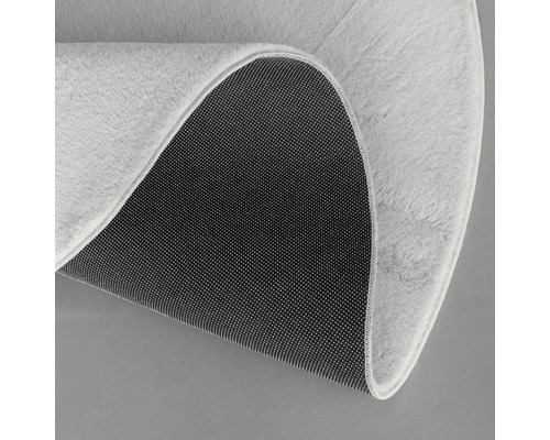 Detailansicht eines runden Teppichs mit Textiloberfläche und rutschfester Unterseite