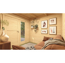 Innenraum eines Gartenhauses mit Sofa, Bildern an der Wand und dekorativen Pflanzen