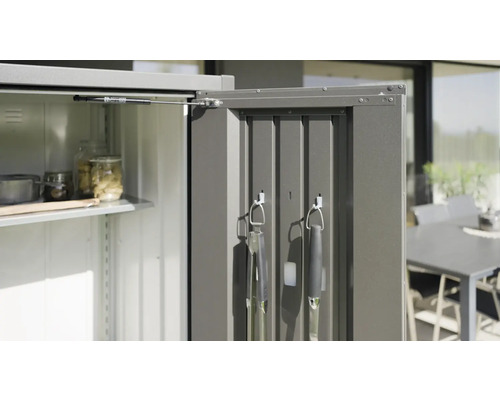 Geöffneter Gartenschrank mit Regalen und Grillutensilien