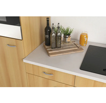 Scène de cuisine avec plaque de cuisson, planches à découper, bouteilles d''huile, plante et bocal en verre sur un comptoir de cuisine