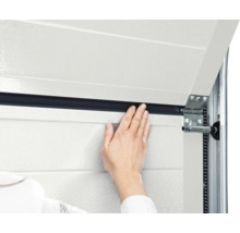 Detailaufnahme einer Hand, die eine Garagentordichtung anbringt