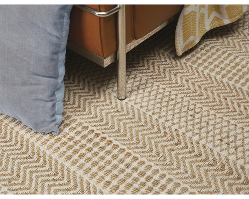 Detailansicht eines Teppichs mit Zickzackmuster unter einem Sessel