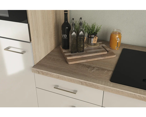 Plan de travail de cuisine avec évier, planches à découper, bouteilles d''huile, herbes aromatiques et boisson