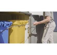 Mülltonnenbox mit blauen und gelben Mülltonnen, bedient von einer Person