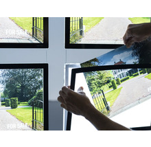 Cadre lumineux avec annonces immobilières et mains changeant une photo