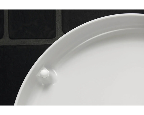 Gros plan d'une soucoupe de pot de fleurs blanche en plastique