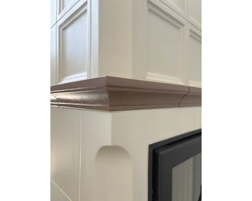 Detailansicht eines Kachelofens mit brauner Bordüre