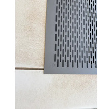 Ausschnitt eines Bodens mit einer grauen Lüftungsabdeckung