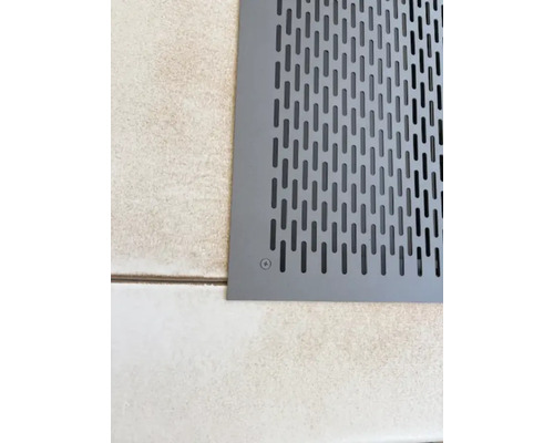 Ausschnitt eines Bodens mit einer grauen Lüftungsabdeckung