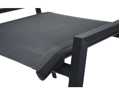 Gros plan d'une chaise de jardin avec assise en textile et accoudoir en métal