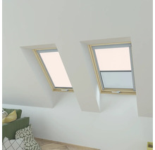 Deux fenêtres de toit avec cadre en bois dans une pièce mansardée lumineuse.