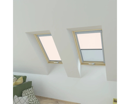 Deux fenêtres de toit avec cadre en bois dans une pièce mansardée lumineuse.