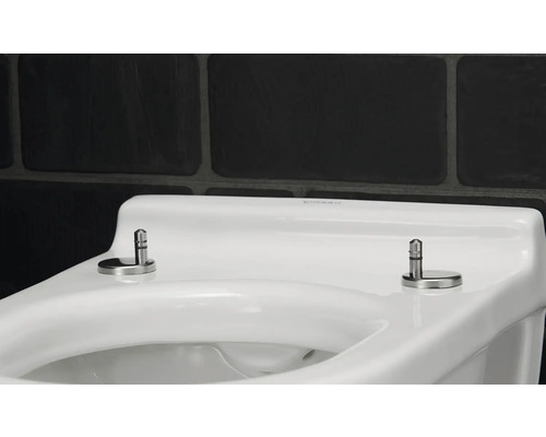 Detailansicht eines weißen Toilettensitzes mit rostfreien Stahlbefestigungen