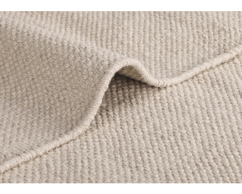 Gros plan d''un tapis beige à la texture tissée