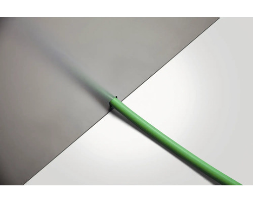 Tuyau d''arrosage vert devant une surface grise et blanche