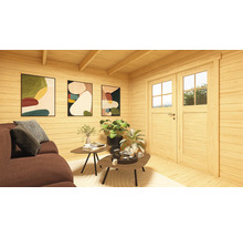 Cabane en bois claire avec canapé, tables, plantes et images décoratives au mur