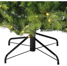 Gros plan sur un sapin de Noël artificiel avec éclairage et support en métal noir