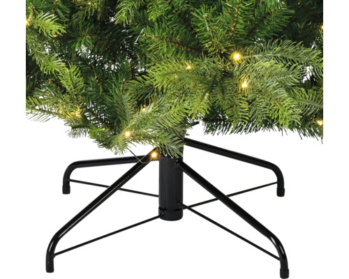 Gros plan sur un sapin de Noël artificiel avec éclairage et support en métal noir