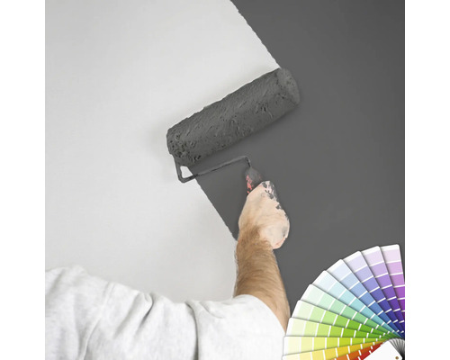 "Une personne peint un mur avec un rouleau à peinture 