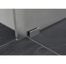 Detail einer Duschkabine mit Wandhalterung auf dunklem Fliesenboden