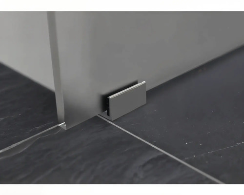 Détail d''une cabine de douche avec fixation murale sur un sol carrelé foncé