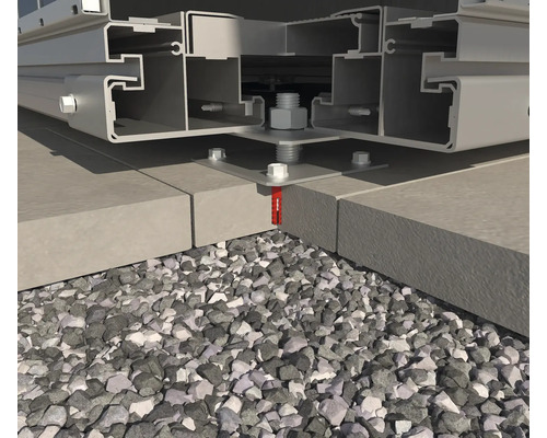 Gros plan d''une structure métallique fixée sur une surface en béton avec des boulons et des chevilles, avec du gravier en dessous
