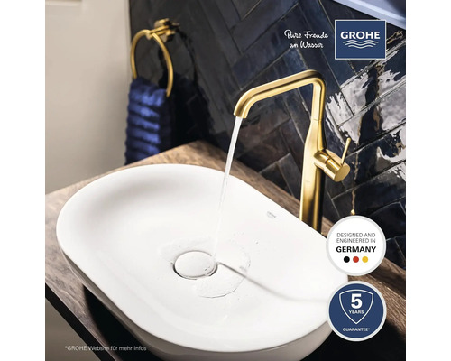 Waschbecken mit goldener Armatur, Handtuchhalter und Grohe Logo
