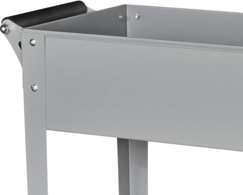 Detailansicht eines grauen Transportwagens aus Metall mit einem schwarzen Griff.