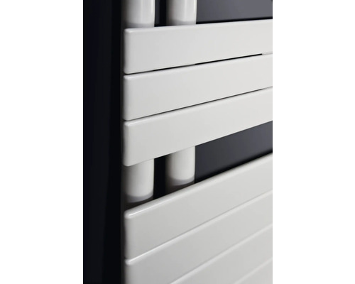 Gros plan d'un radiateur de salle de bain blanc avec des éléments chauffants horizontaux.