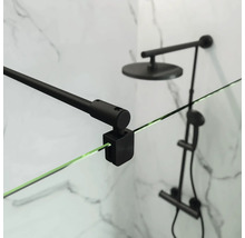 Gros plan d'une cabine de douche avec support noir et pommeau de douche devant un mur en marbre